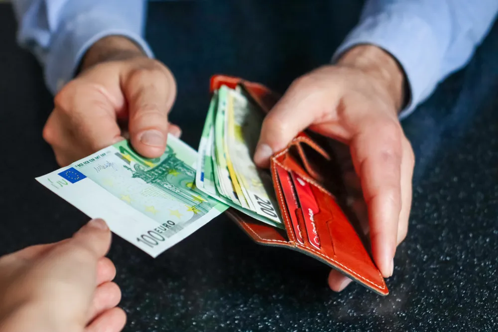Bureau avec calculatrice, dossier de regroupement de crédits ouvert et tableau de mensualités annoté