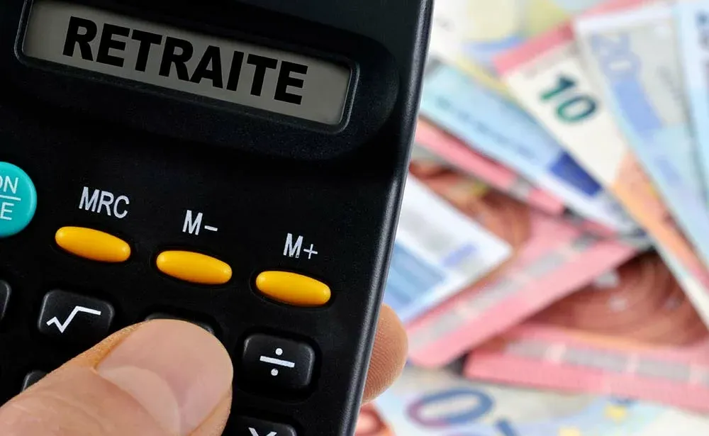 Bureau avec calculatrice, dossier de regroupement de crédits ouvert et tableau de mensualités annoté